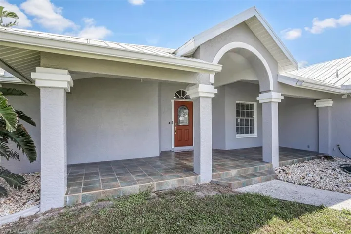 View of exterior entry featuring covered porch