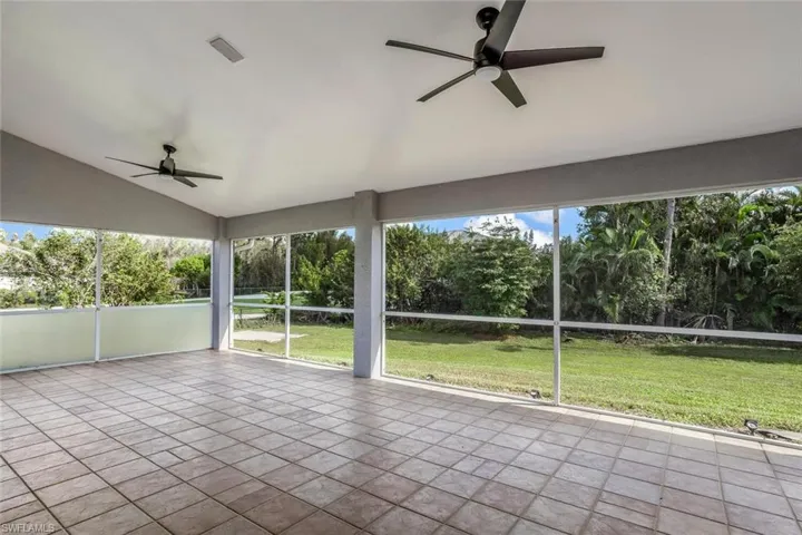 Unfurnished sunroom with ceiling fan and lofted ceiling
