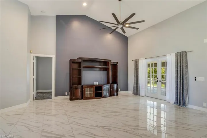Living room with french doors, high vaulted ceiling, and ceiling fan