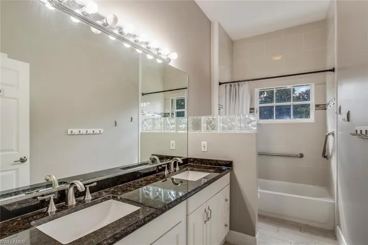 Bathroom featuring hardwood / wood-style floors, vanity, and shower / tub combo