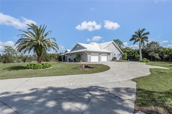 View of front facade featuring a garage and a front lawn