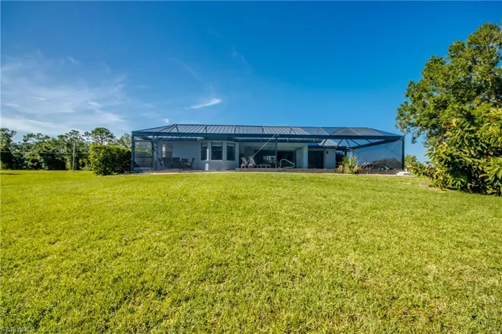 Back of property with a lawn and enclosure