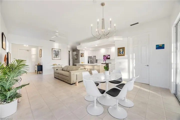 Dining room featuring a chandelier, ceiling fan, and light tile patterned flooring
