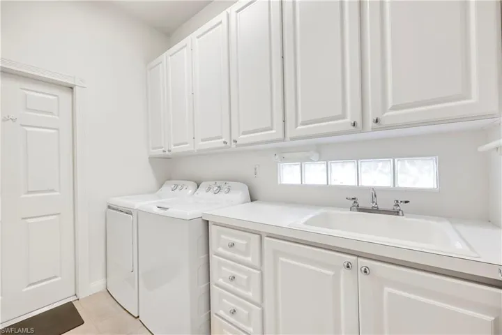 Laundry area featuring washer and clothes dryer and cabinet space