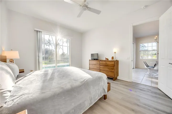 Bedroom featuring light wood-style flooring, access to outside, ceiling fan, and multiple windows