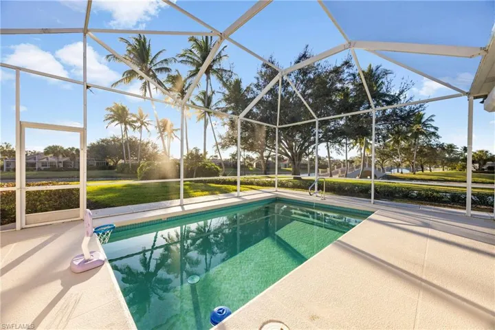 Swimming pool featuring screen, a sunroom, and a lawn