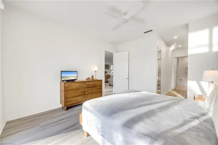 Bedroom featuring light wood-style floors, a ceiling fan, recessed lighting, and connected bathroom