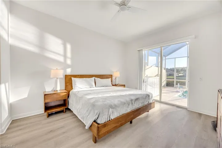 Bedroom with light wood-style flooring, access to outside, and a ceiling fan