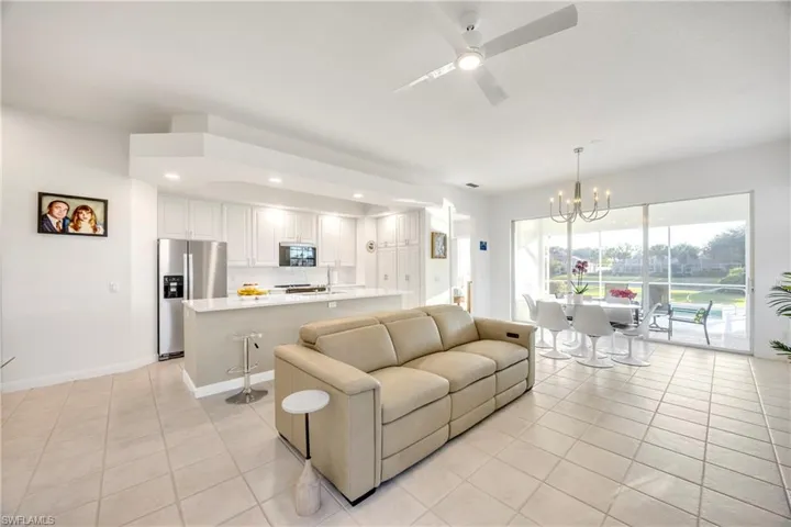 Living room with a ceiling fan, a chandelier, light tile patterned floors, and recessed lighting