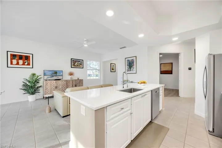 Kitchen featuring appliances with stainless steel finishes, light tile patterned floors, ceiling fan, recessed lighting, and a center island with sink