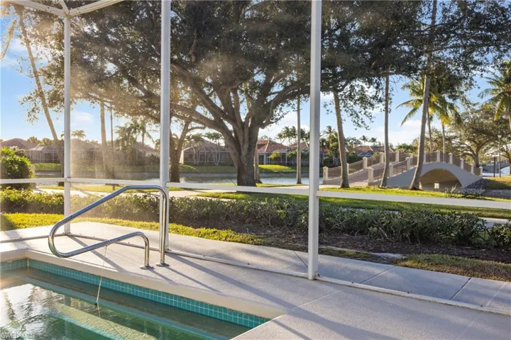View of pool with a water view and a sunroom
