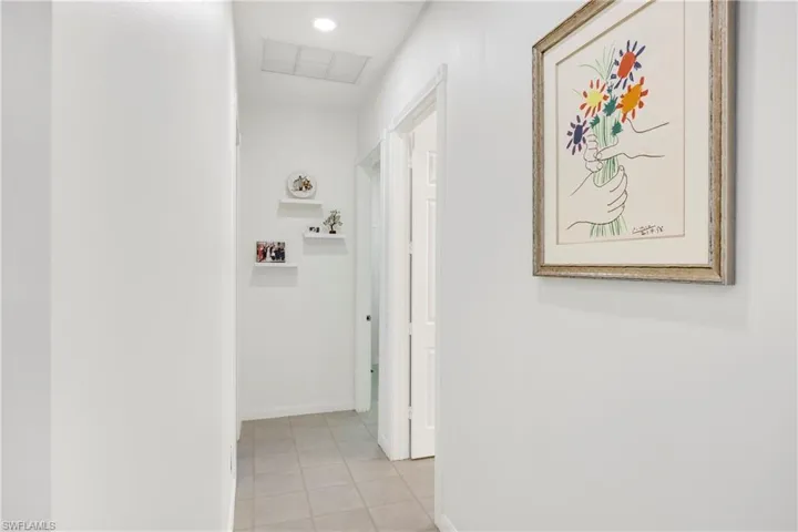 Hallway with baseboards and light tile patterned flooring