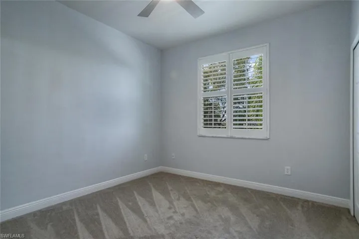 Unfurnished room featuring carpet floors, ceiling fan, and baseboards