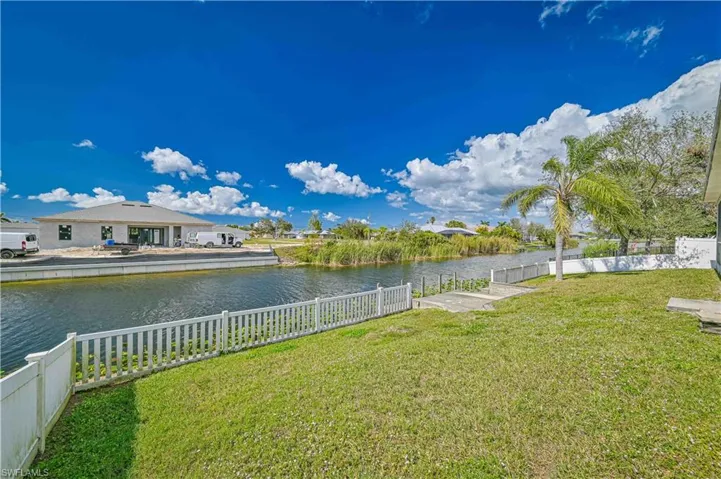 View of yard featuring a water view and fence