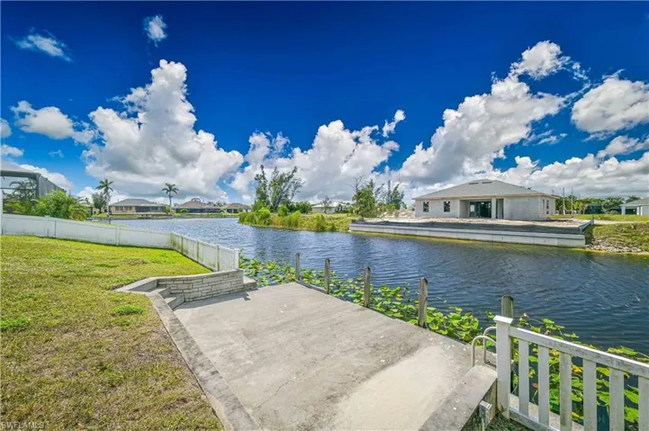 Property view of water with a dock and fence