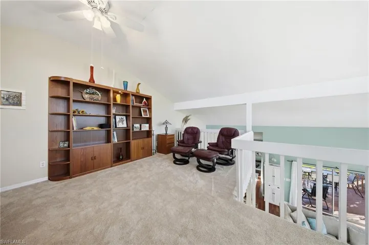 Sitting room with lofted ceiling, carpet, and a ceiling fan