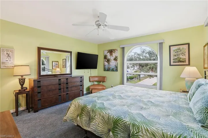 Carpeted bedroom with a ceiling fan
