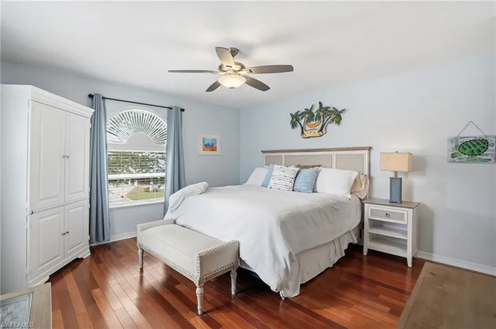 Bedroom featuring dark wood finished floors and ceiling fan - Virtually Edited Image