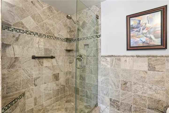 Bathroom featuring a tile shower and a wainscoted wall - Virtually Edited Image