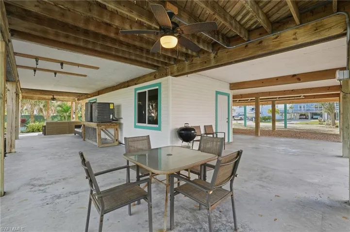 View of patio with a ceiling fan, outdoor dining area, and area for grilling - Virtually Edited Image