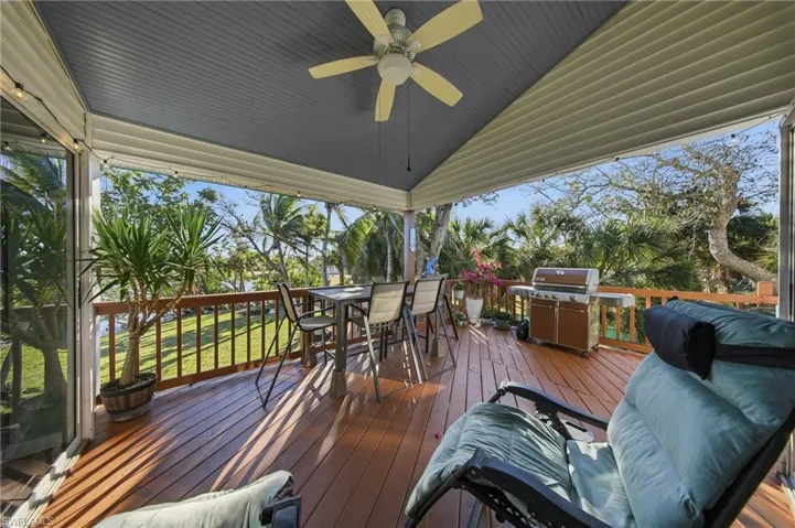 Deck with a ceiling fan, area for grilling, and outdoor dining area