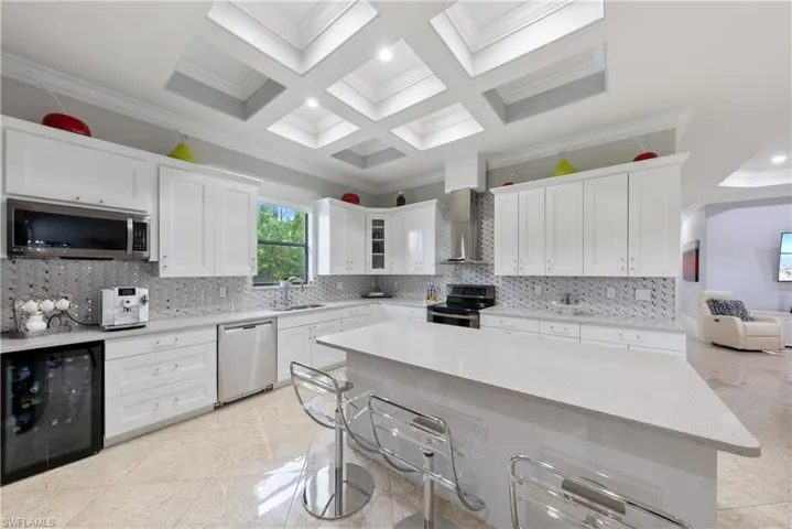Kitchen featuring crown molding, white cabinetry, wine cooler, and stainless steel appliances