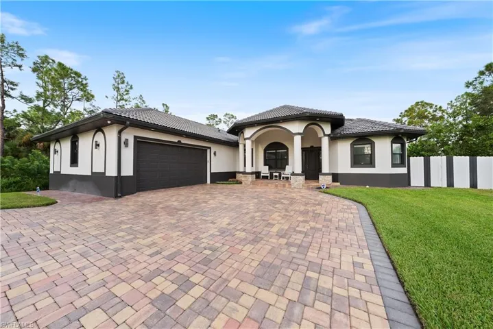 View of front of home featuring a front yard and a garage