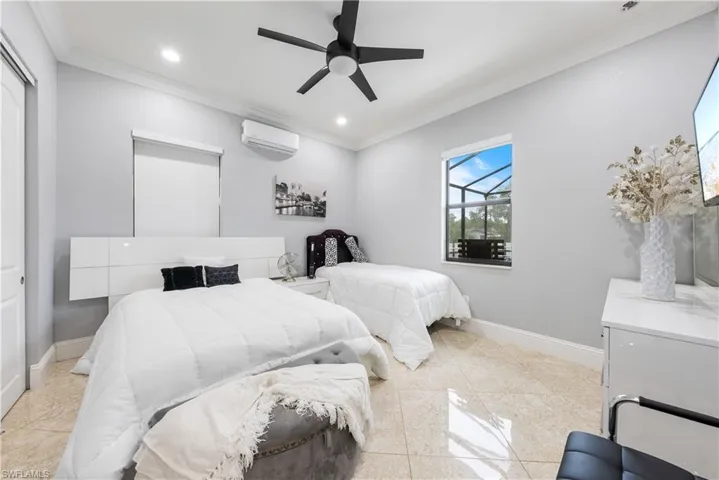 Bedroom featuring ornamental molding, ceiling fan, and a wall mounted air conditioner