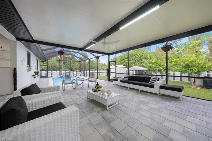 View of patio / terrace with ceiling fan, outdoor lounge area, a fenced in pool, a storage shed, and glass enclosure