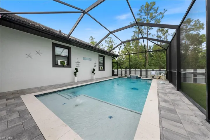 View of swimming pool with a lanai, a patio, and pool water feature