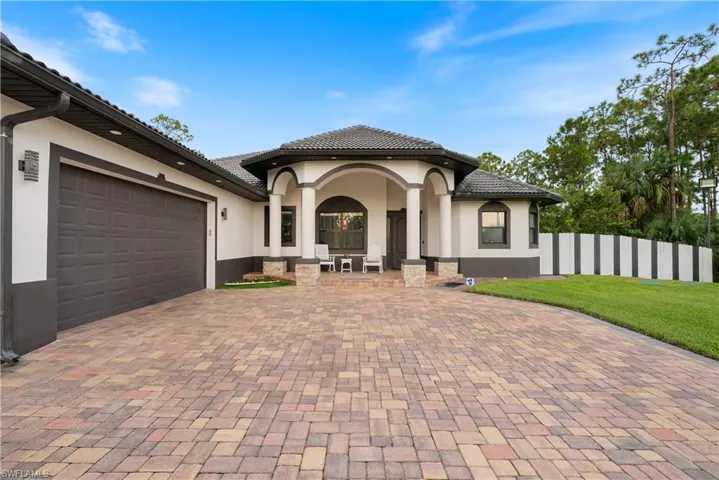 Mediterranean / spanish-style house with a garage and a front lawn