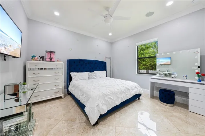 Bedroom featuring ornamental molding, ceiling fan, and light tile patterned floors