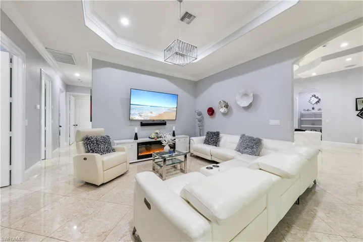 Living room with ornamental molding and a tray ceiling
