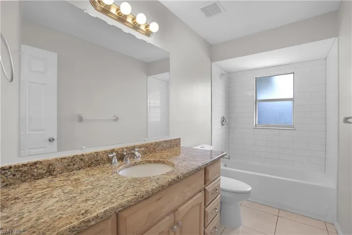 Bathroom featuring a vanity with a light-toned countertop, a rectangular undermount sink, and a chrome faucet
