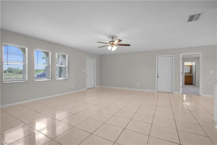 Spacious living area featuring large format tile flooring and neutral wall tones