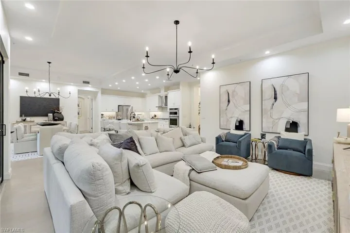 Living room with a raised ceiling and a chandelier