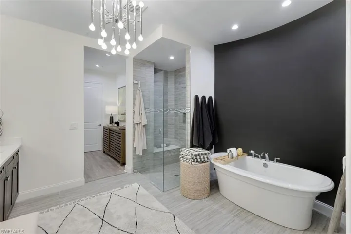 Bathroom featuring a notable chandelier, tile patterned floors, and shower with separate bathtub