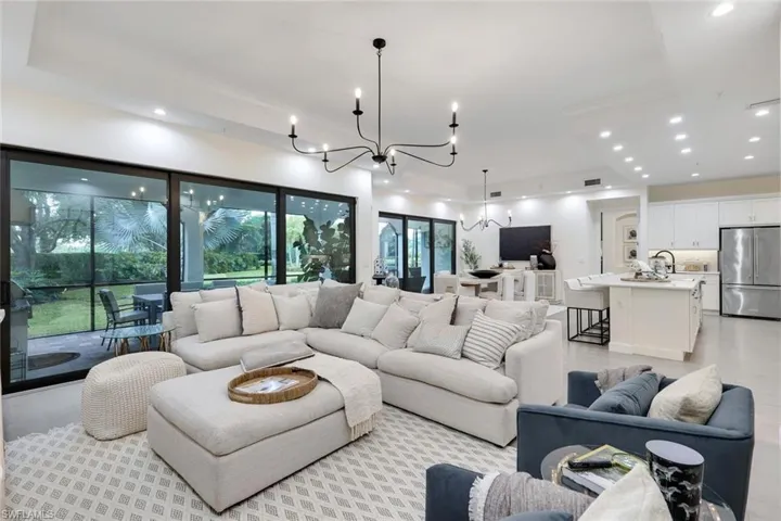 Living room with a tray ceiling and a notable chandelier