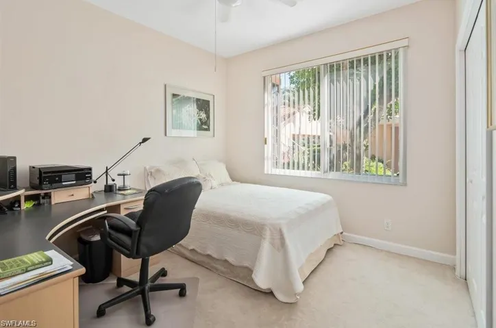 Carpeted bedroom featuring a closet and ceiling fan