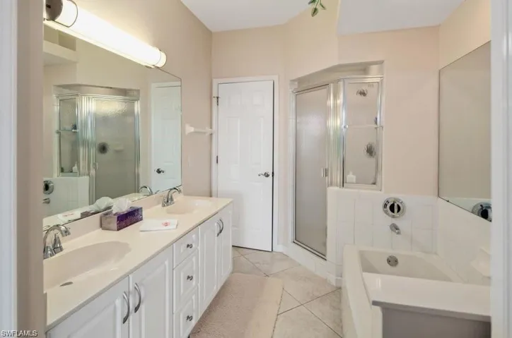 Bathroom featuring vanity, plus walk in shower, and tile patterned flooring
