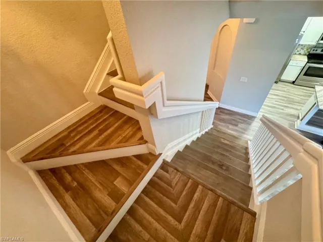 Stairs with wood finished floors and baseboards