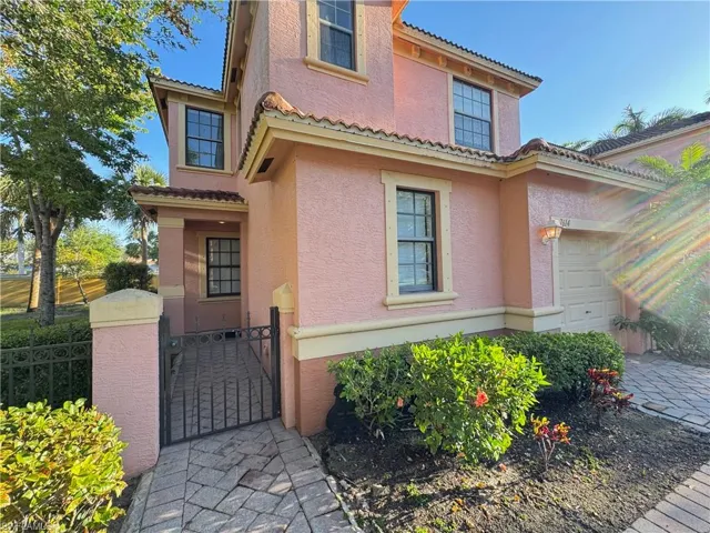 Doorway to property with stucco siding, a garage, fence, and a gate
