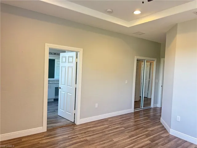Spare room featuring dark wood-style flooring, baseboards, recessed lighting, and a smoke detector