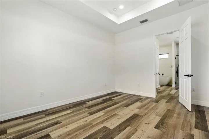 Unfurnished bedroom with wood finished floors and a closet