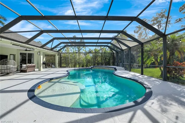 View of swimming pool with a patio area, glass enclosure, and ceiling fan