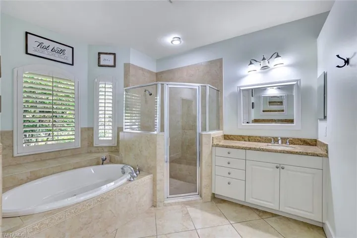 Bathroom with vanity, separate shower and tub, and tile patterned flooring