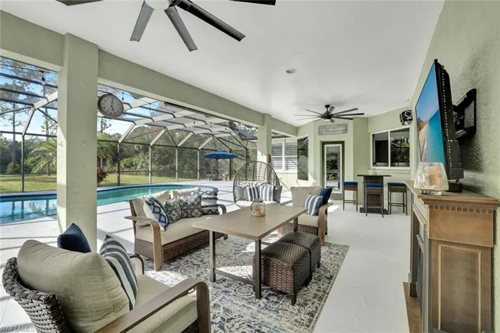View of patio / terrace featuring ceiling fan, glass enclosure, and an outdoor hangout area