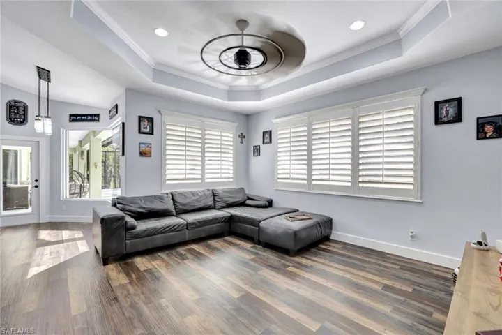 Living room featuring crown molding, plenty of natural light, and dark hardwood / wood-style floors