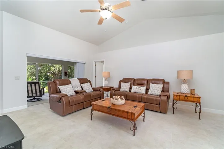 Living room with high vaulted ceiling and a ceiling fan
