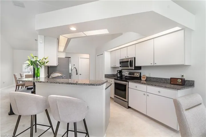 Kitchen with a breakfast bar, appliances with stainless steel finishes